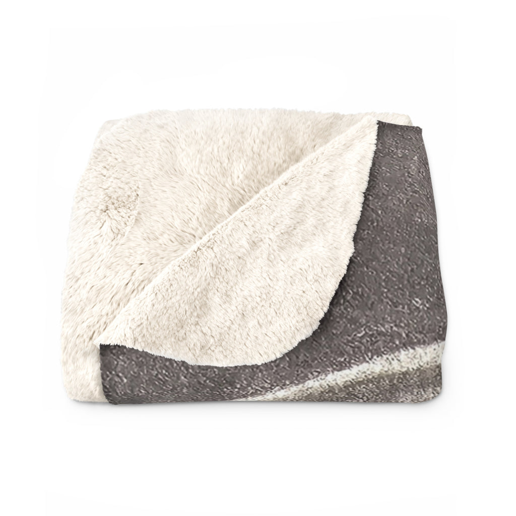 Sherpa-style blanket with cream texture and dark gray acoustic guitar design across the fold