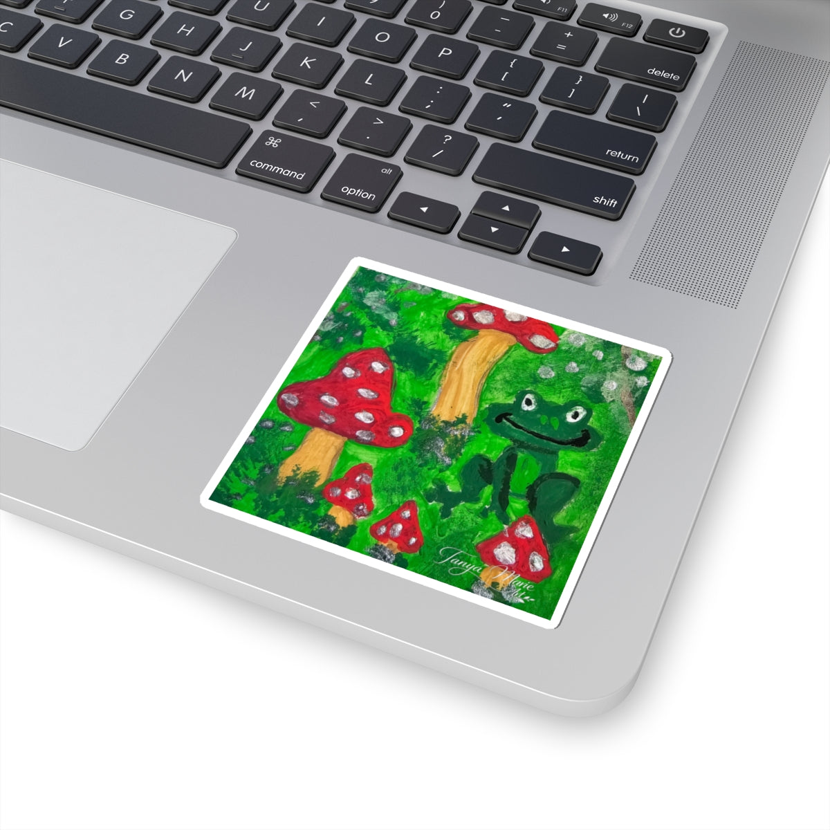 Kiss-cut garden sticker with smiling green frog and red toadstools, white border