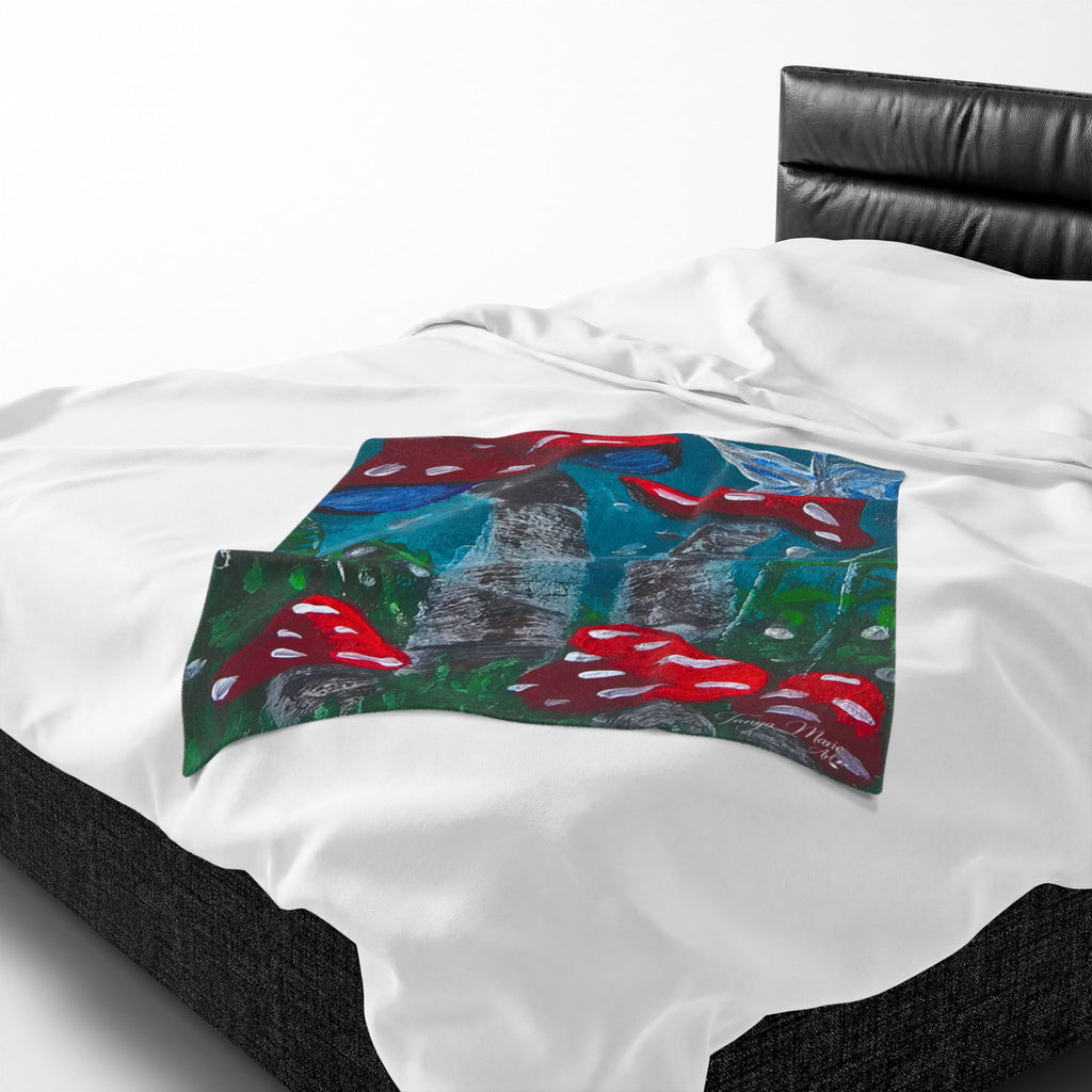 Close-up of white plush throw blanket with blue-green mushroom print panel