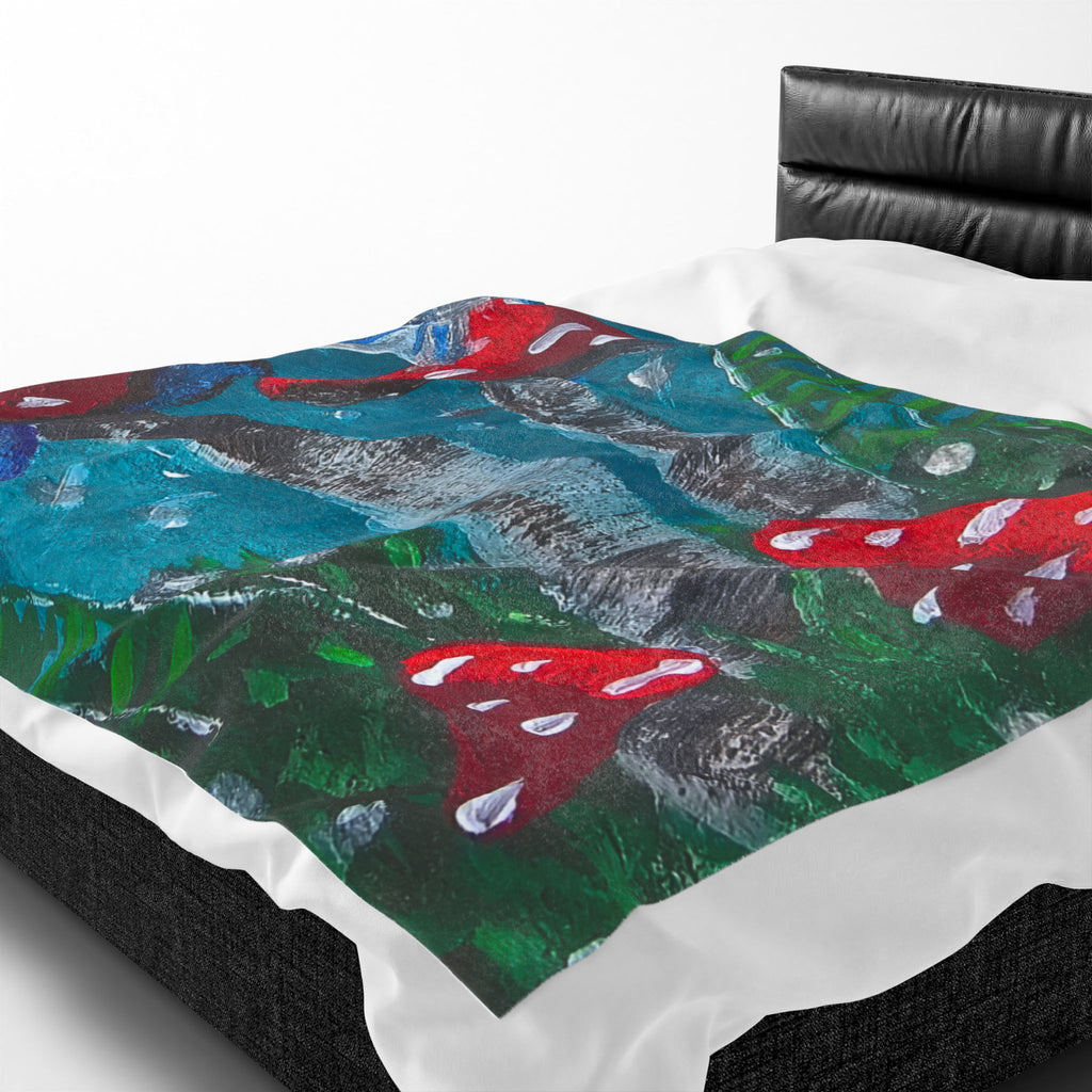 Close view of velveteen plush blanket: red mushrooms on teal forest, green foliage accents