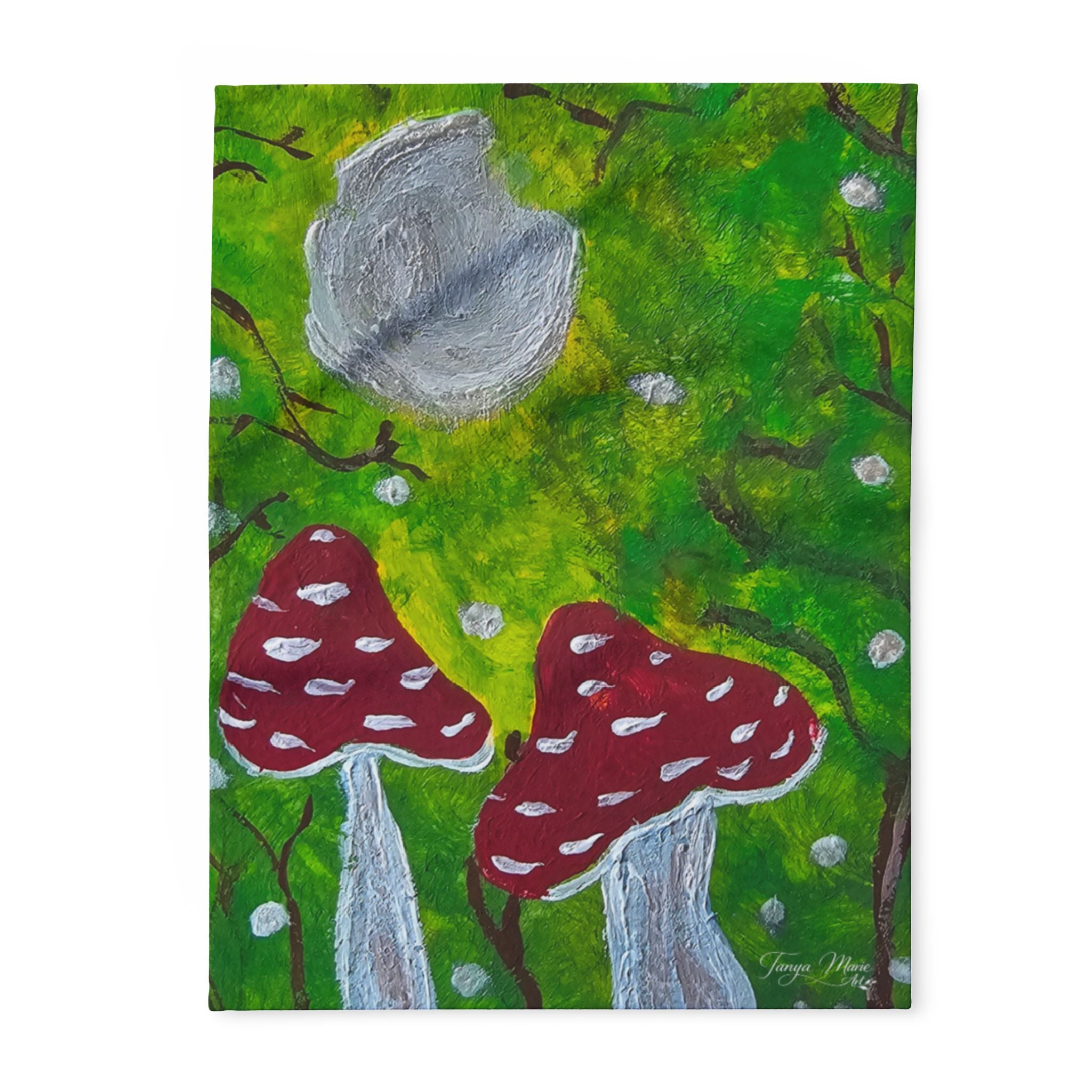 Fleece blanket close-up view of green forest, gray moon, and red mushroom shapes
