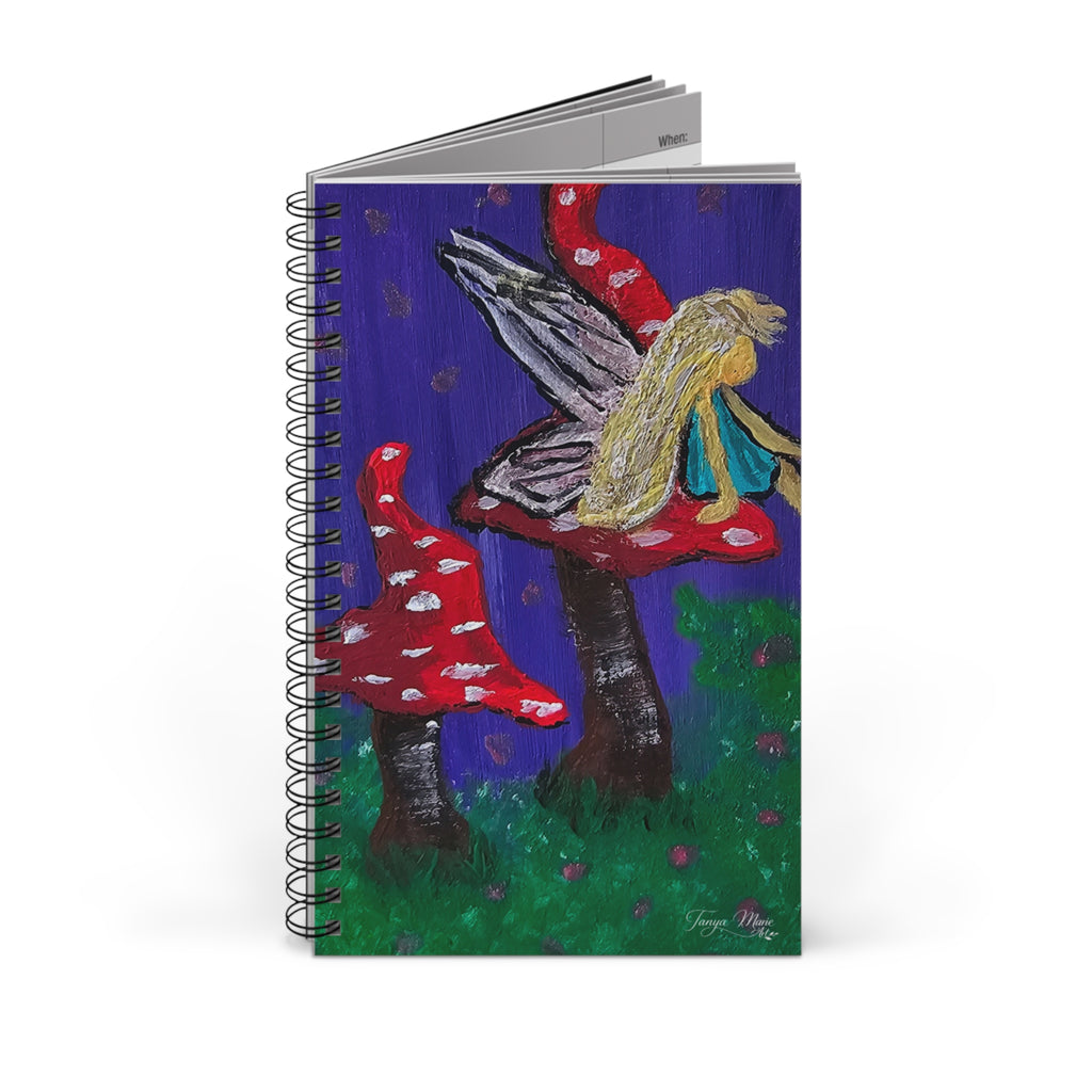 Spiral journal with fairy and mushroom illustration on a blue cover and black coil