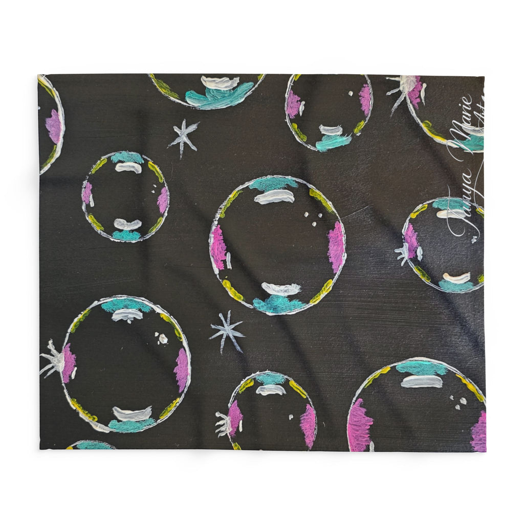 Fleece throw blanket spread flat, dark base with colorful bubble/planet circles and stars