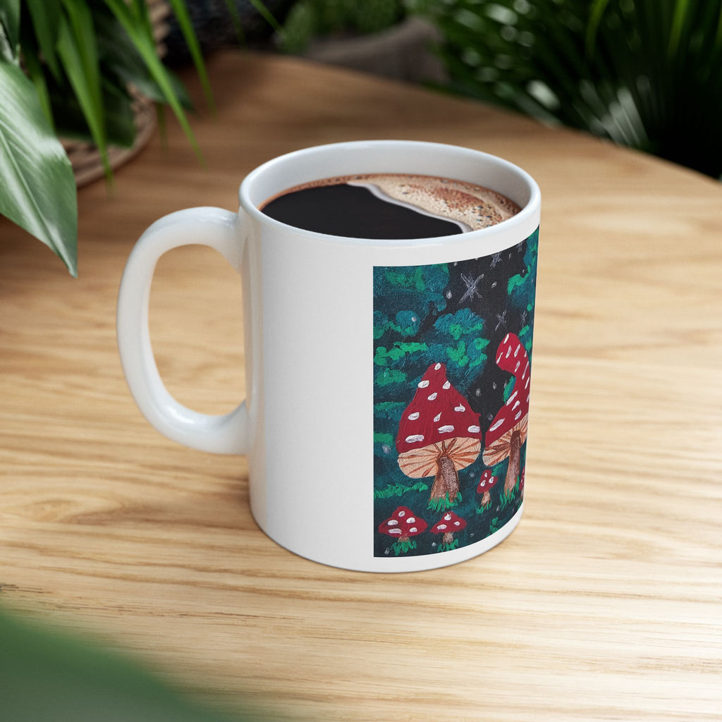 White ceramic coffee mug with red toadstool mushroom forest print, filled with coffee