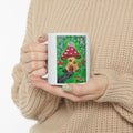 White ceramic mug with colorful mushroom cottage scene illustration on front