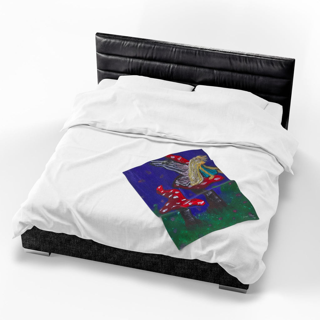 White plush throw blanket with fairy and toadstool graphic, shown on dark bed frame