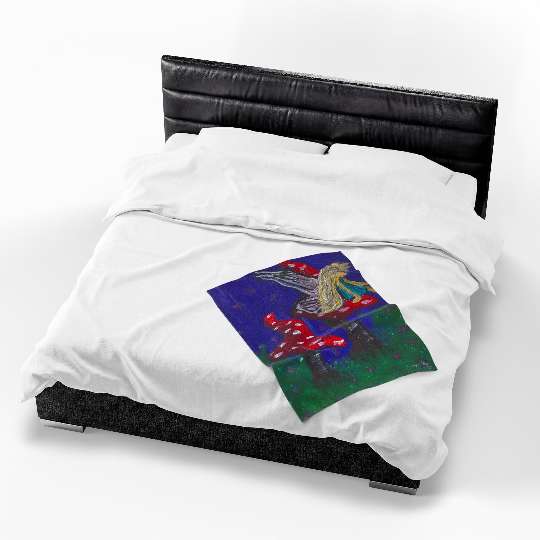 White plush throw blanket with fairy and toadstool graphic, shown on dark bed frame