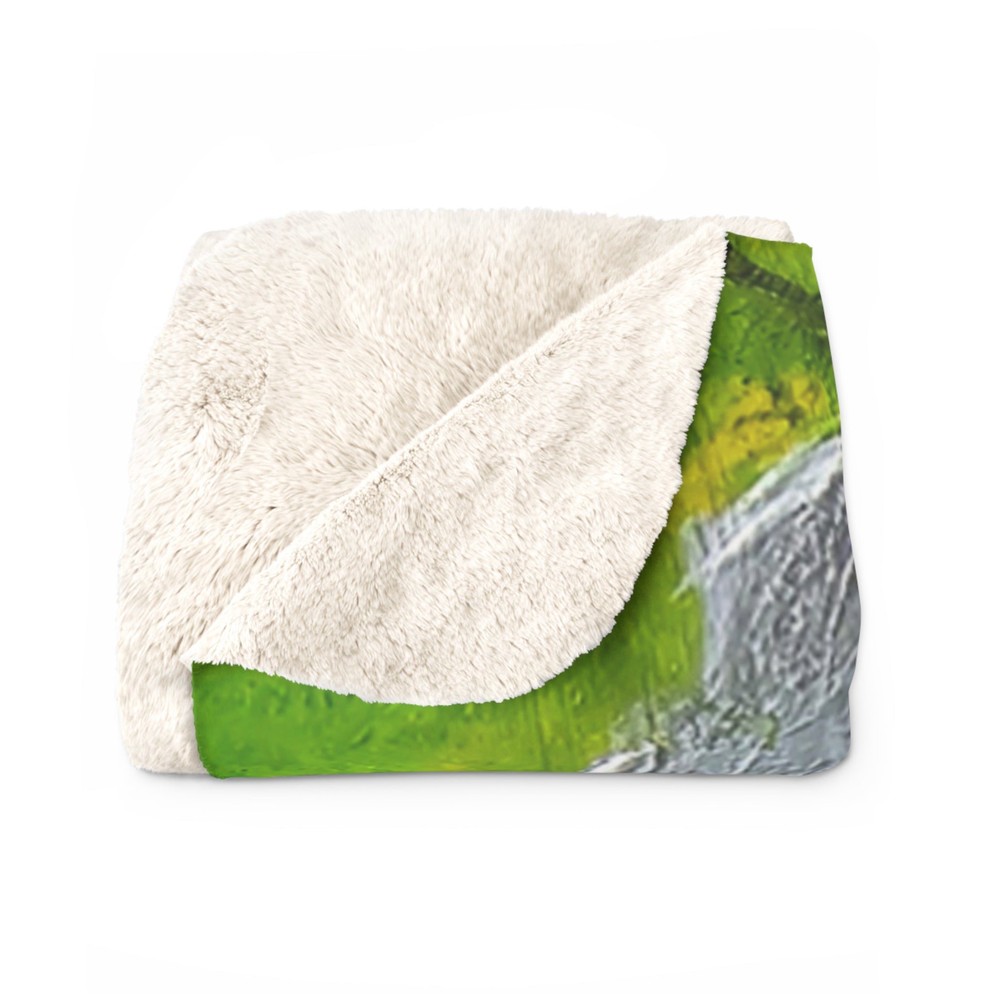 Sherpa blanket folded with off-white sherpa fleece top and green forest print beneath