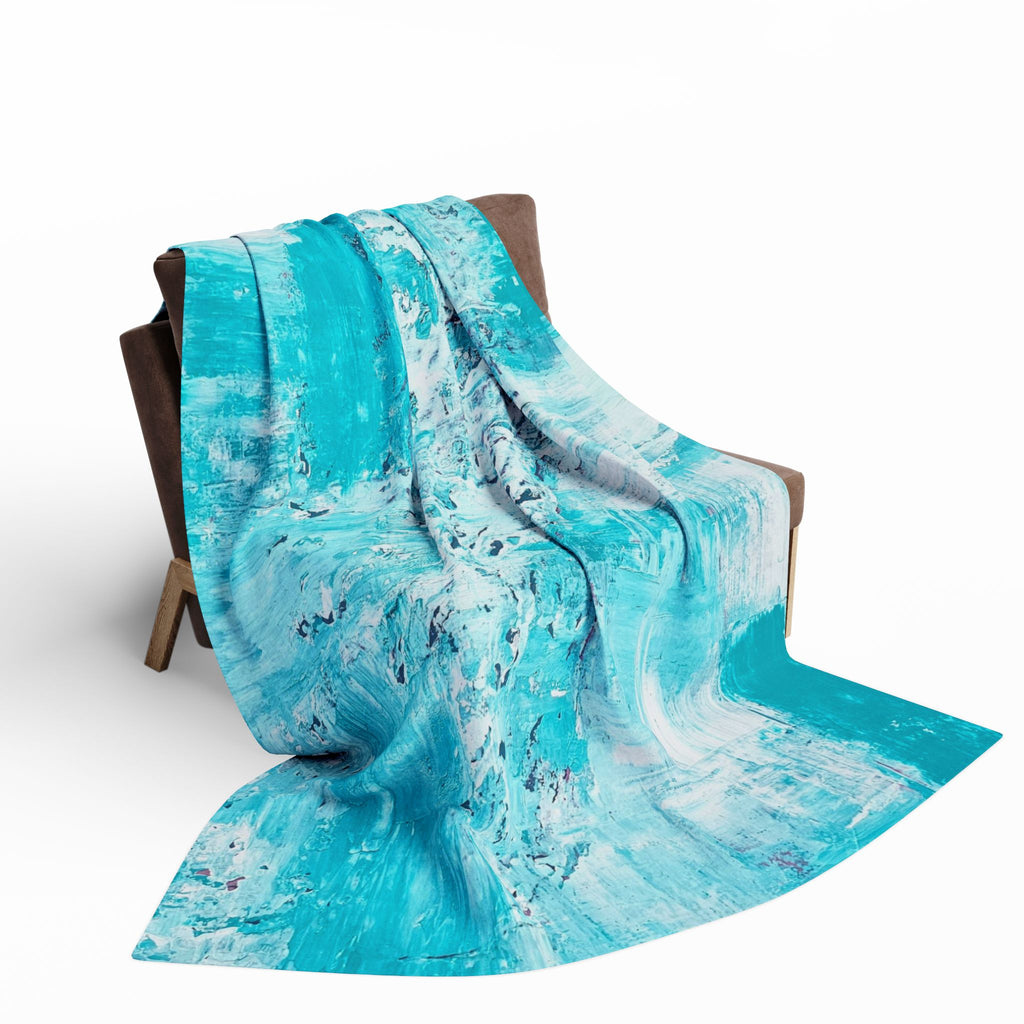 Turquoise abstract fleece blanket draped on chair, flowing splash-streak fabric