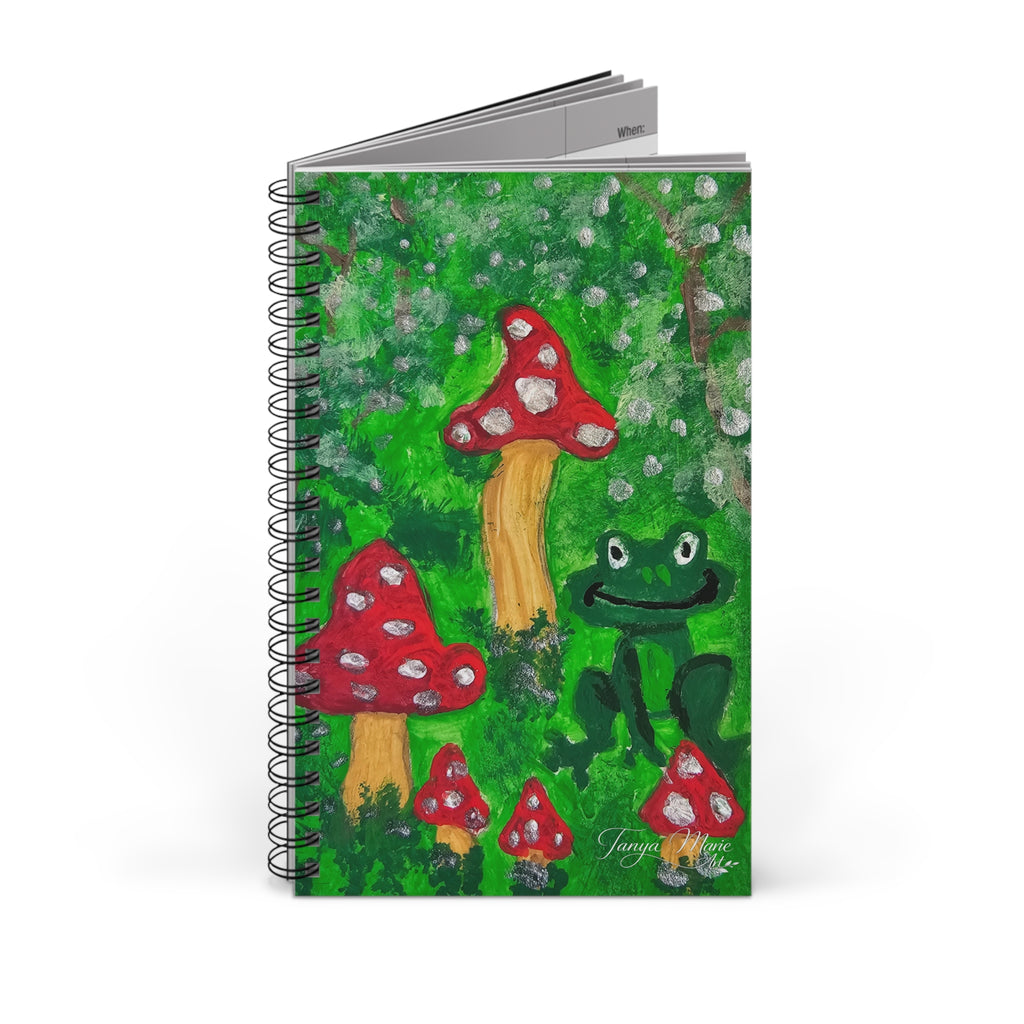 Spiral journal cover with green forest illustration of mushrooms and frog; black rings