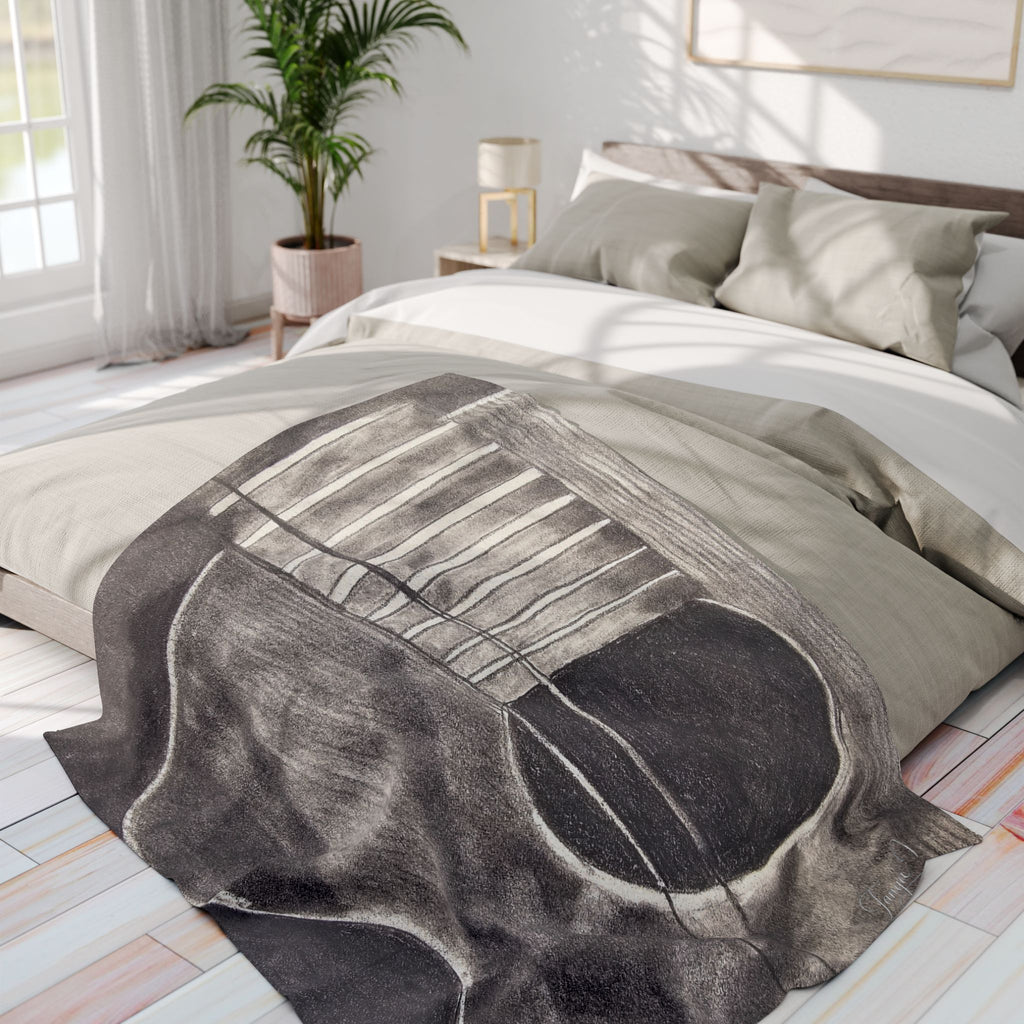 Gray fleece blanket on bed with large acoustic guitar graphic