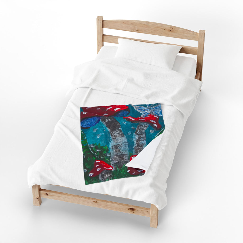 White plush throw blanket on bed with centered mushroom print square