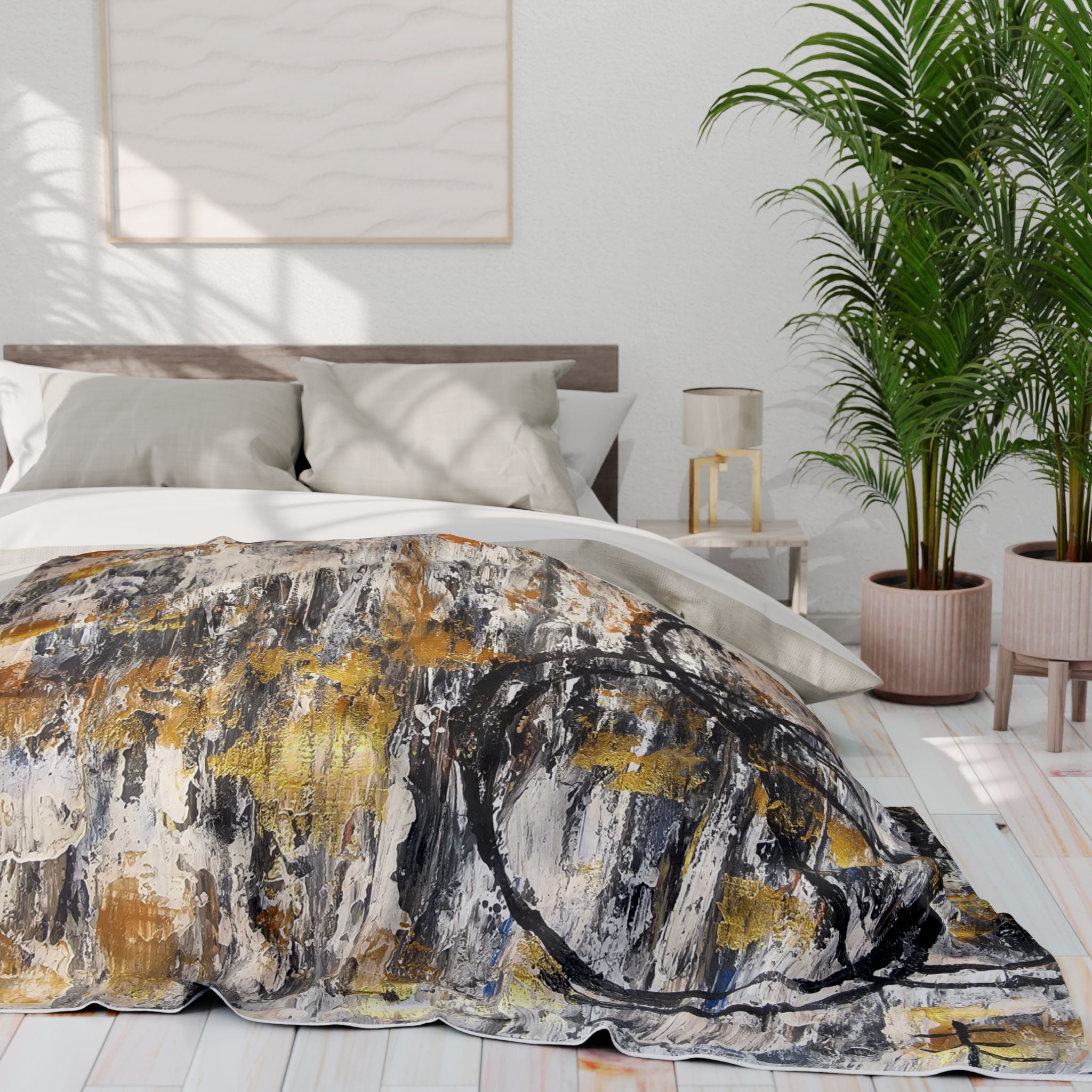 Abstract fleece blanket draped over bed, featuring gold dashes and dark circular marks