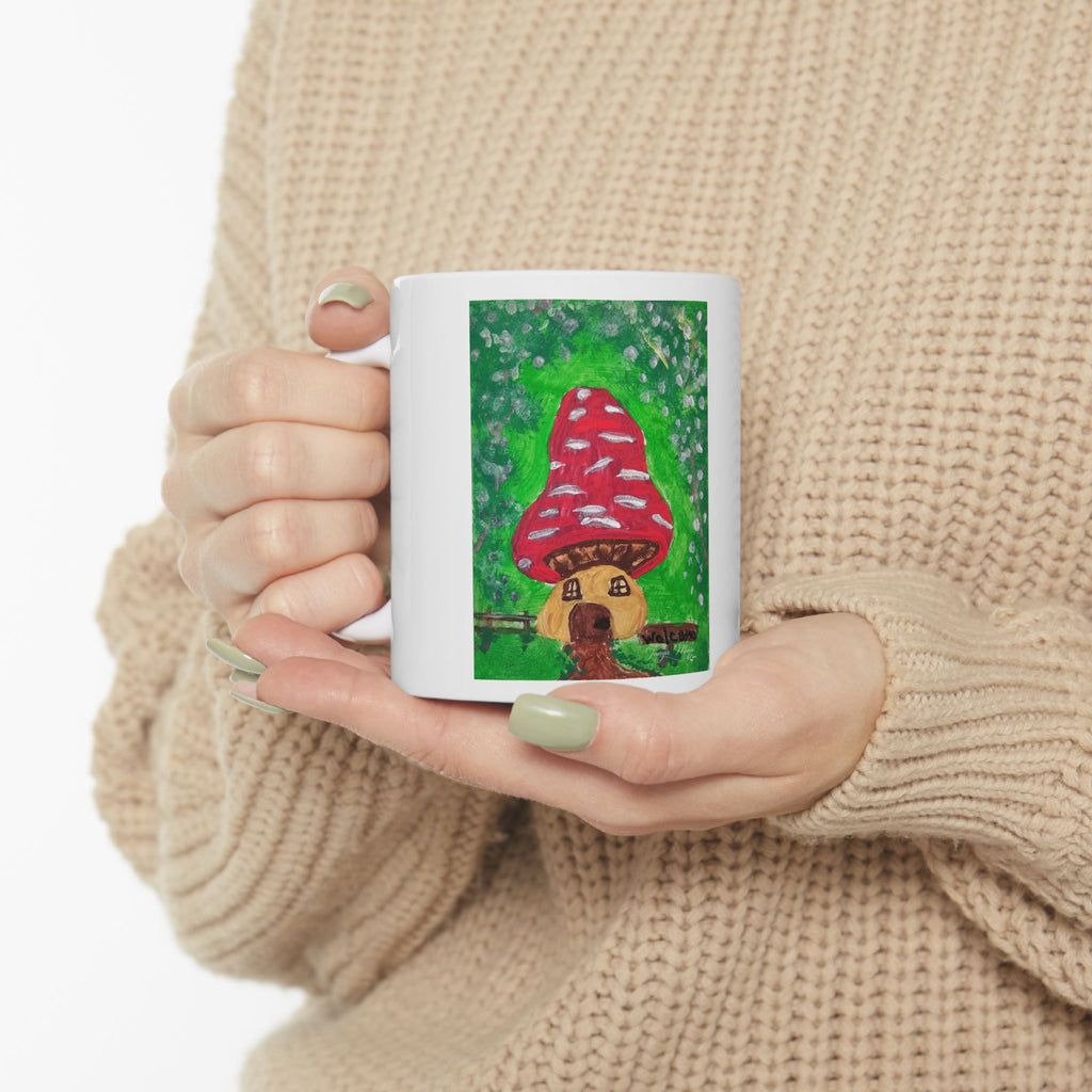 White ceramic mug with red mushroom house illustration on the front panel