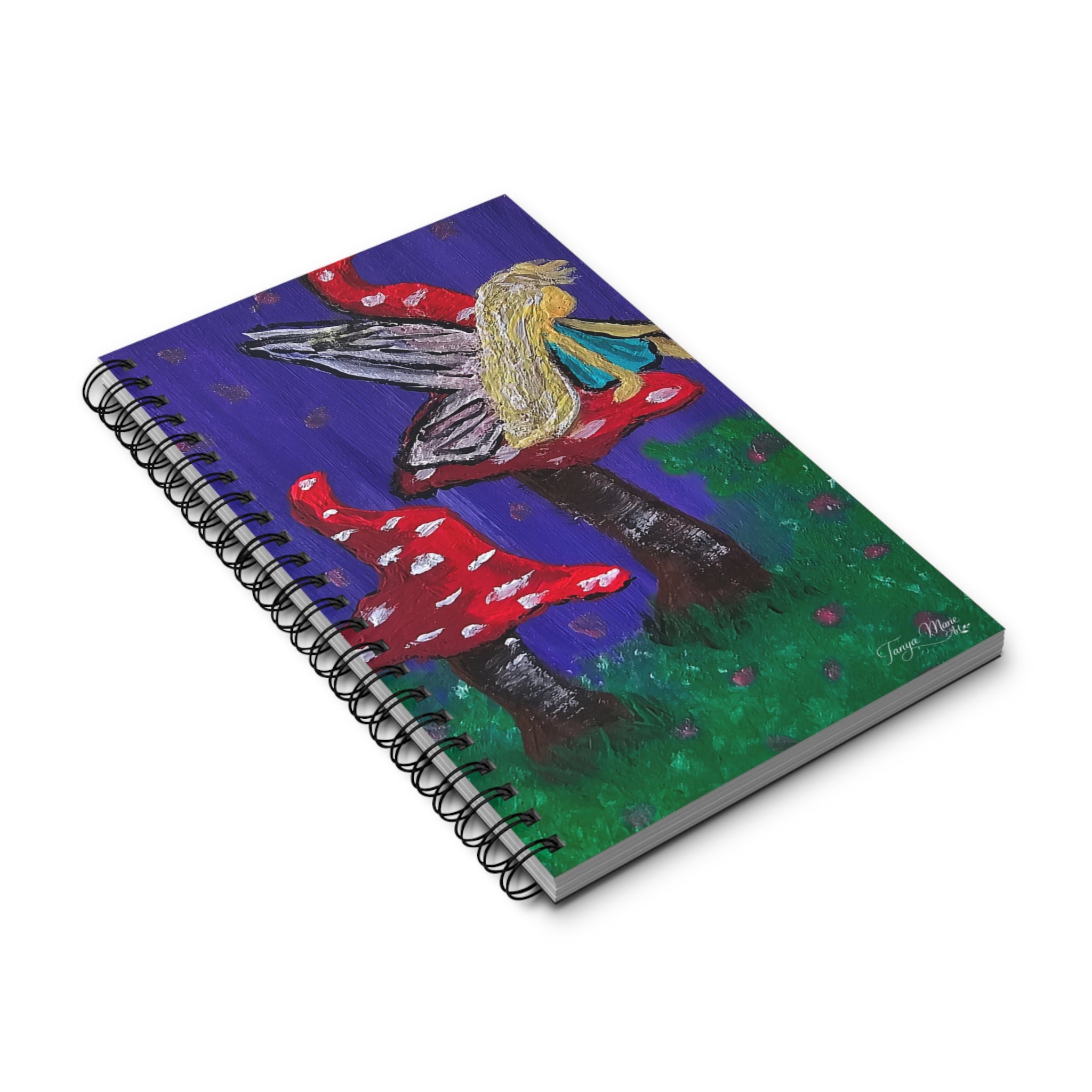 Angled view of fairy mushroom spiral journal with black coil binding and vivid cover illustration.