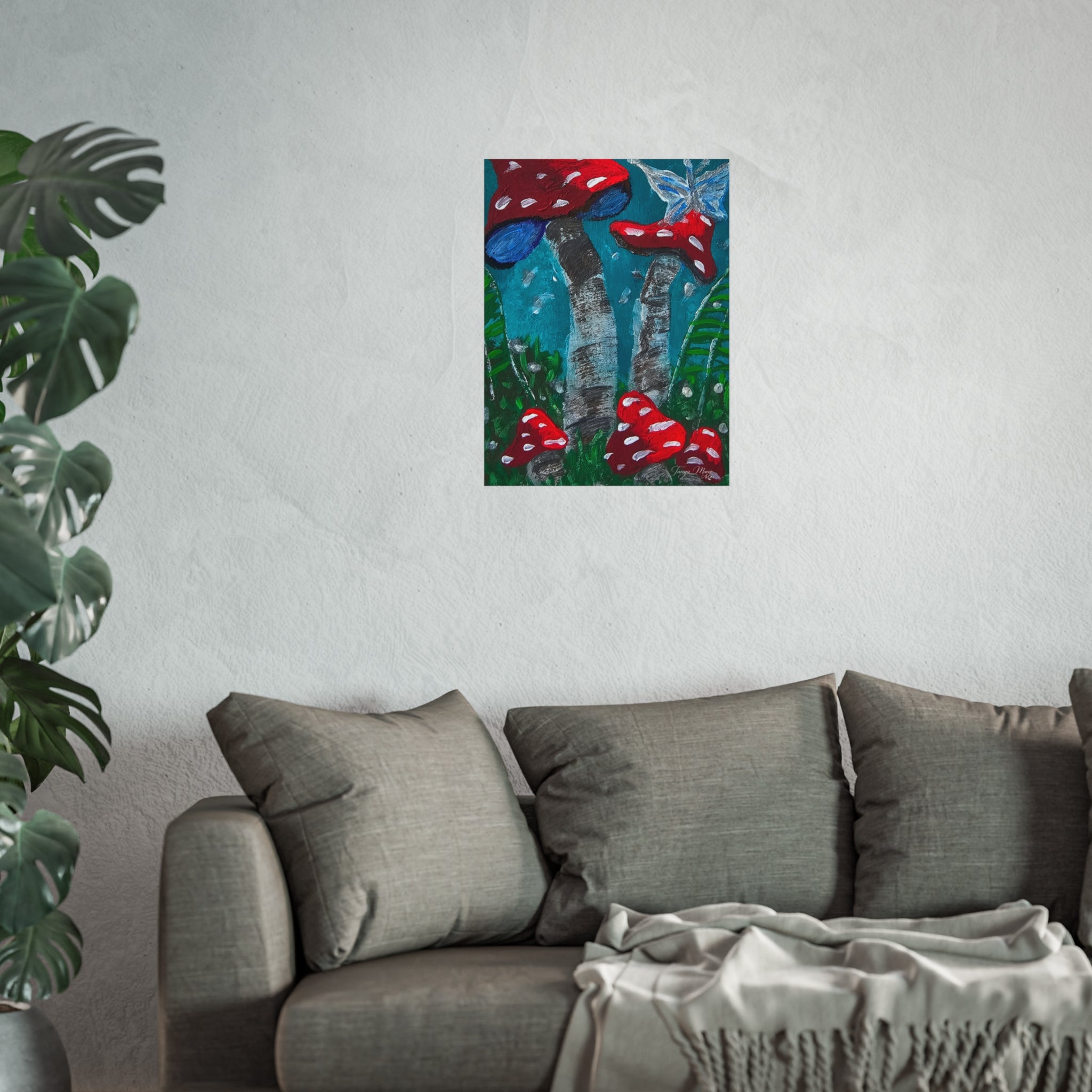 Mushroom garden wall poster with red toadstools centered above a gray sofa and throw blanket