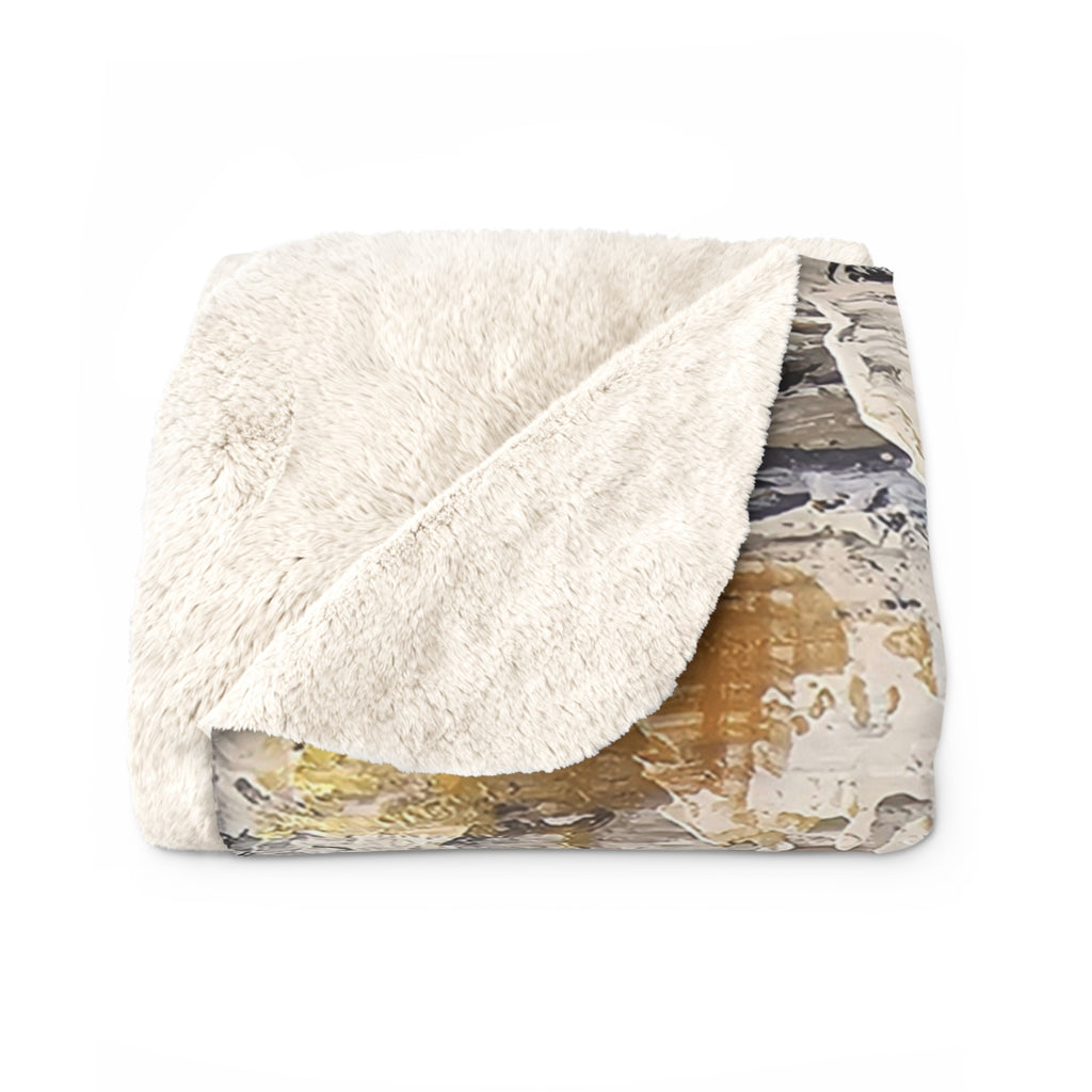 Sherpa blanket folded to show soft cream fleece on top and abstract art underside