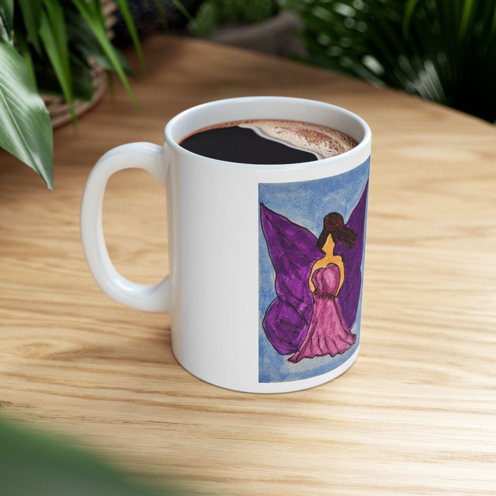 White ceramic mug with purple fairy print, filled with hot coffee on a wood table