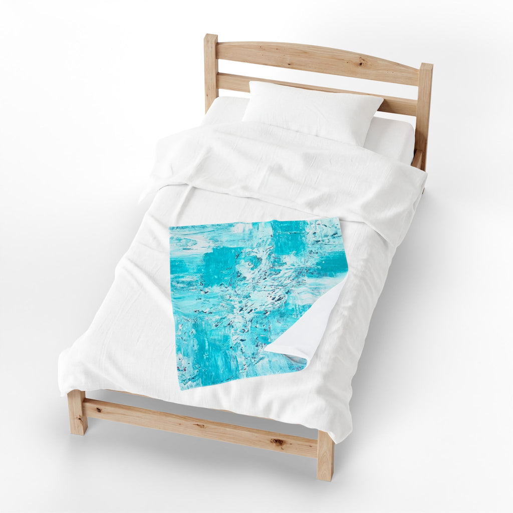 Turquoise abstract plush throw blanket with blue square artwork patch on white fabric