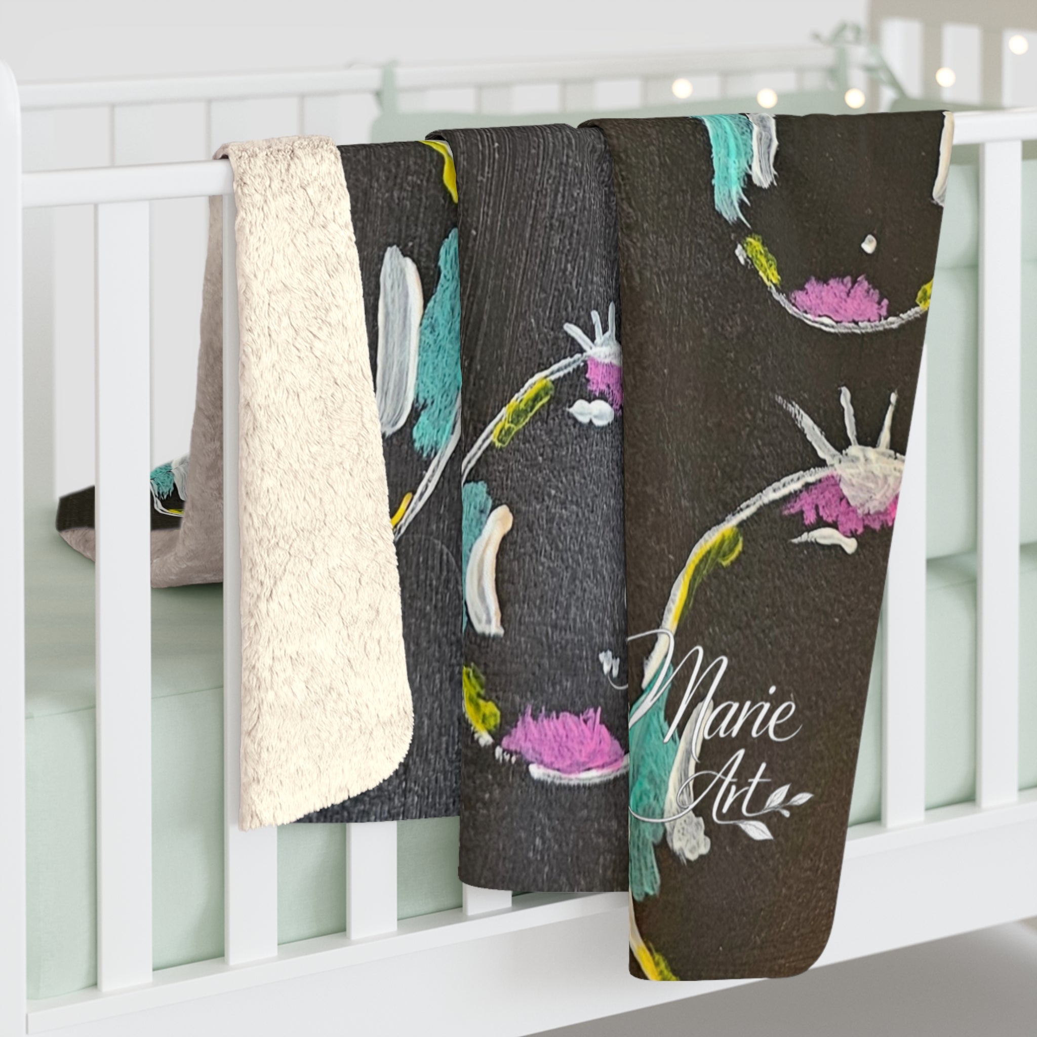 Sherpa fleece blanket draped on crib rail, fluffy white sherpa edge with dark bubble pattern