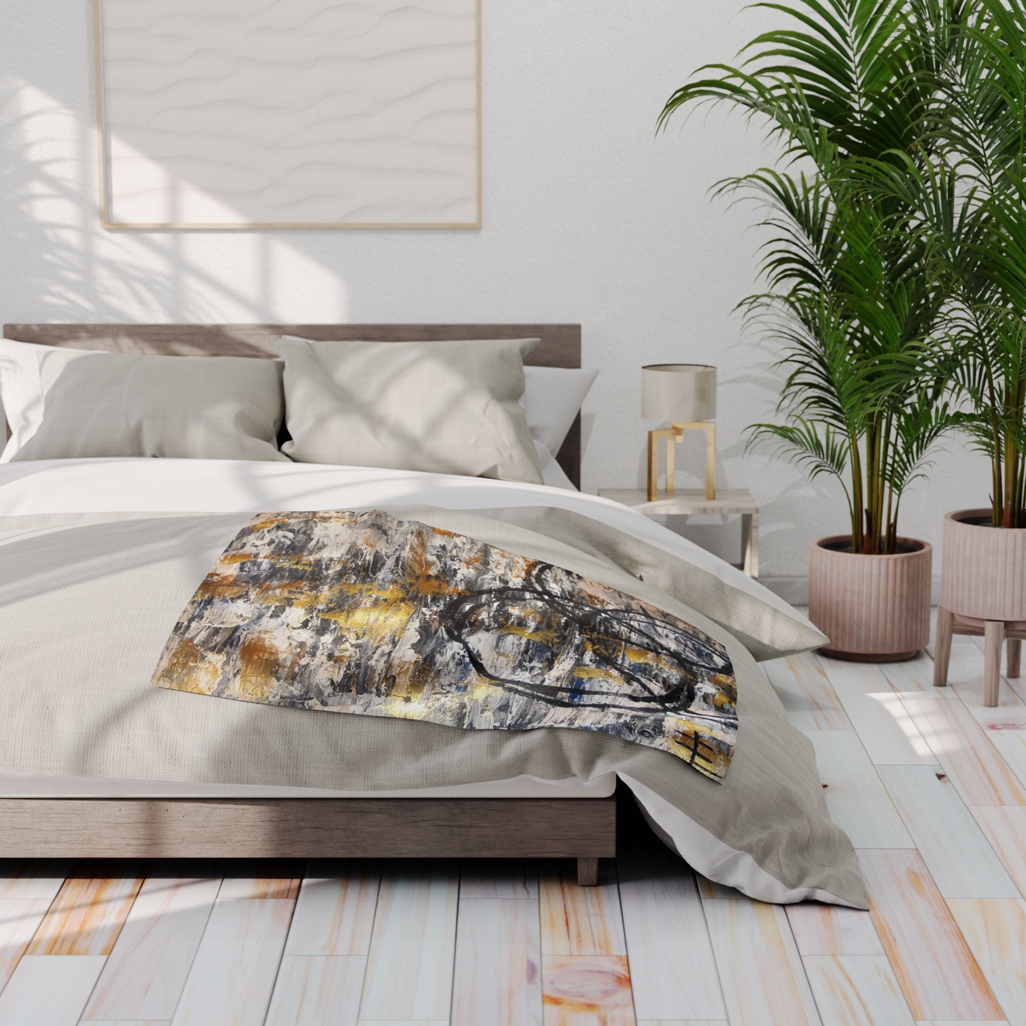 Fleece throw blanket with abstract grey, gold, and black circle print on a bed