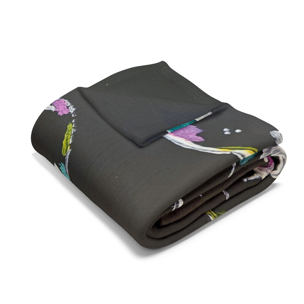 Black fleece throw blanket, folded, with colorful bubble print pattern.