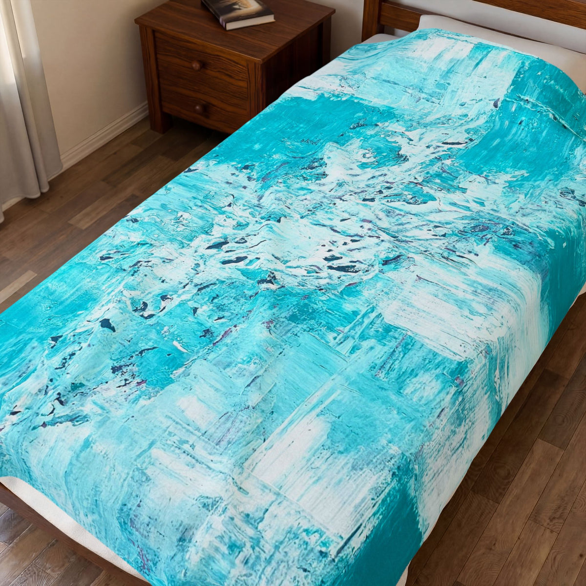 Turquoise abstract plush blanket draped on bed, with white border