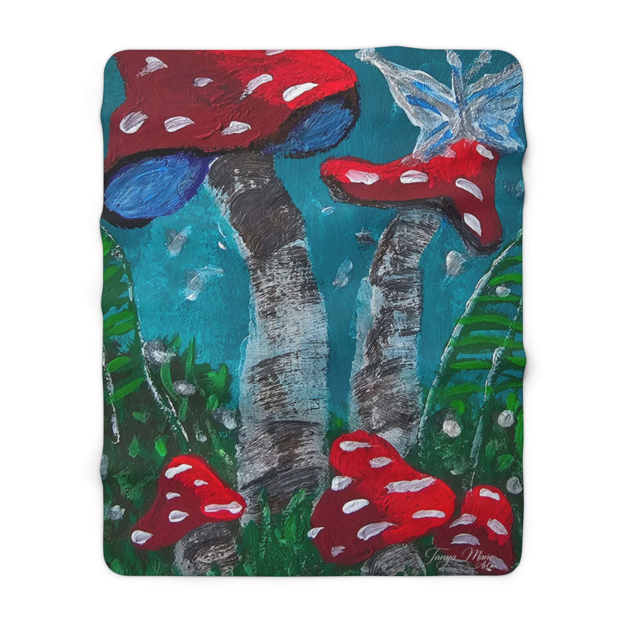Sherpa blanket with blue-green forest print, red toadstools on gray tree trunks.
