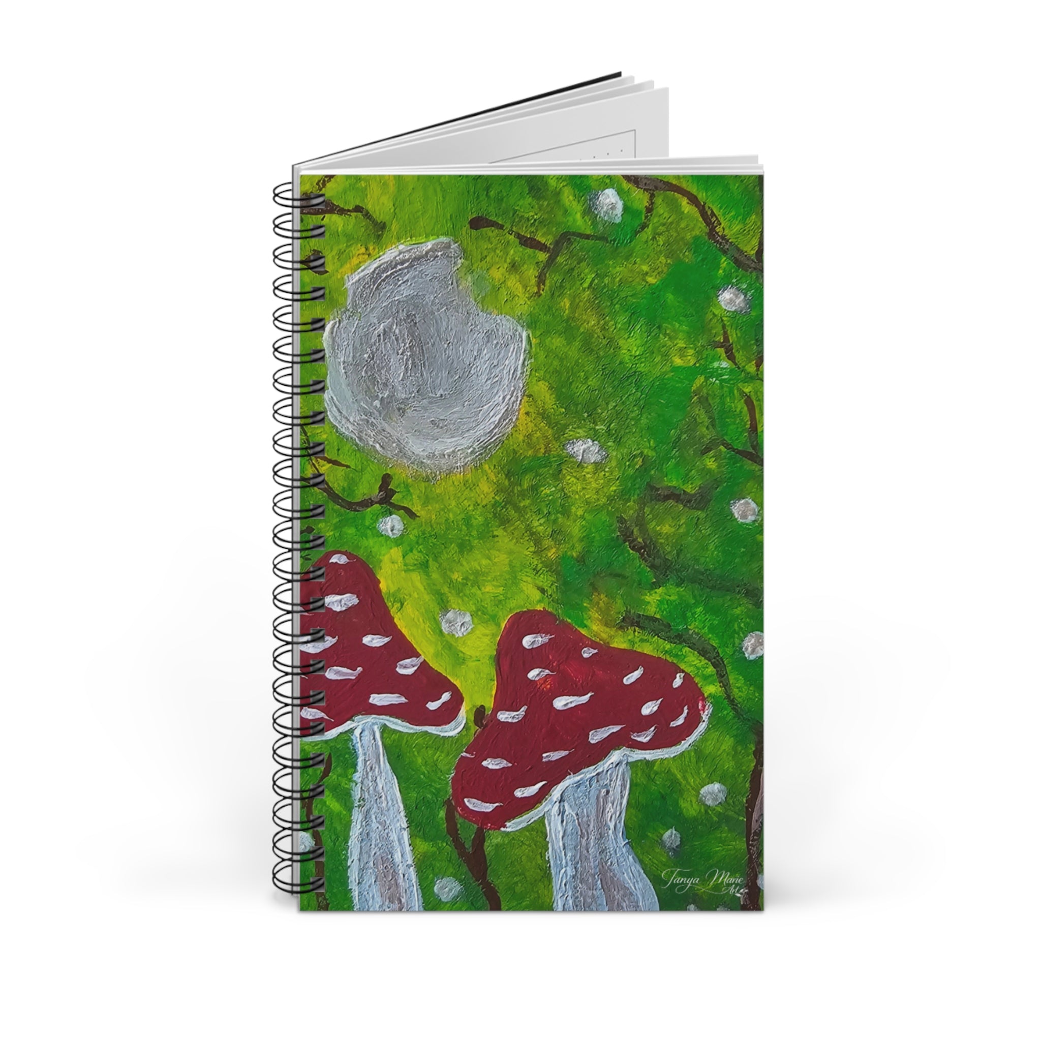 Spiral journal notebook with green cover illustration, gray moon, and red mushrooms, with extra pages