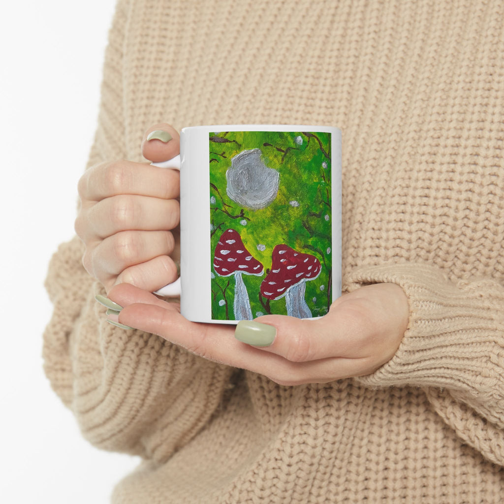 Ceramic mug with green woodland scene and red toadstools, gray mushroom cap artwork
