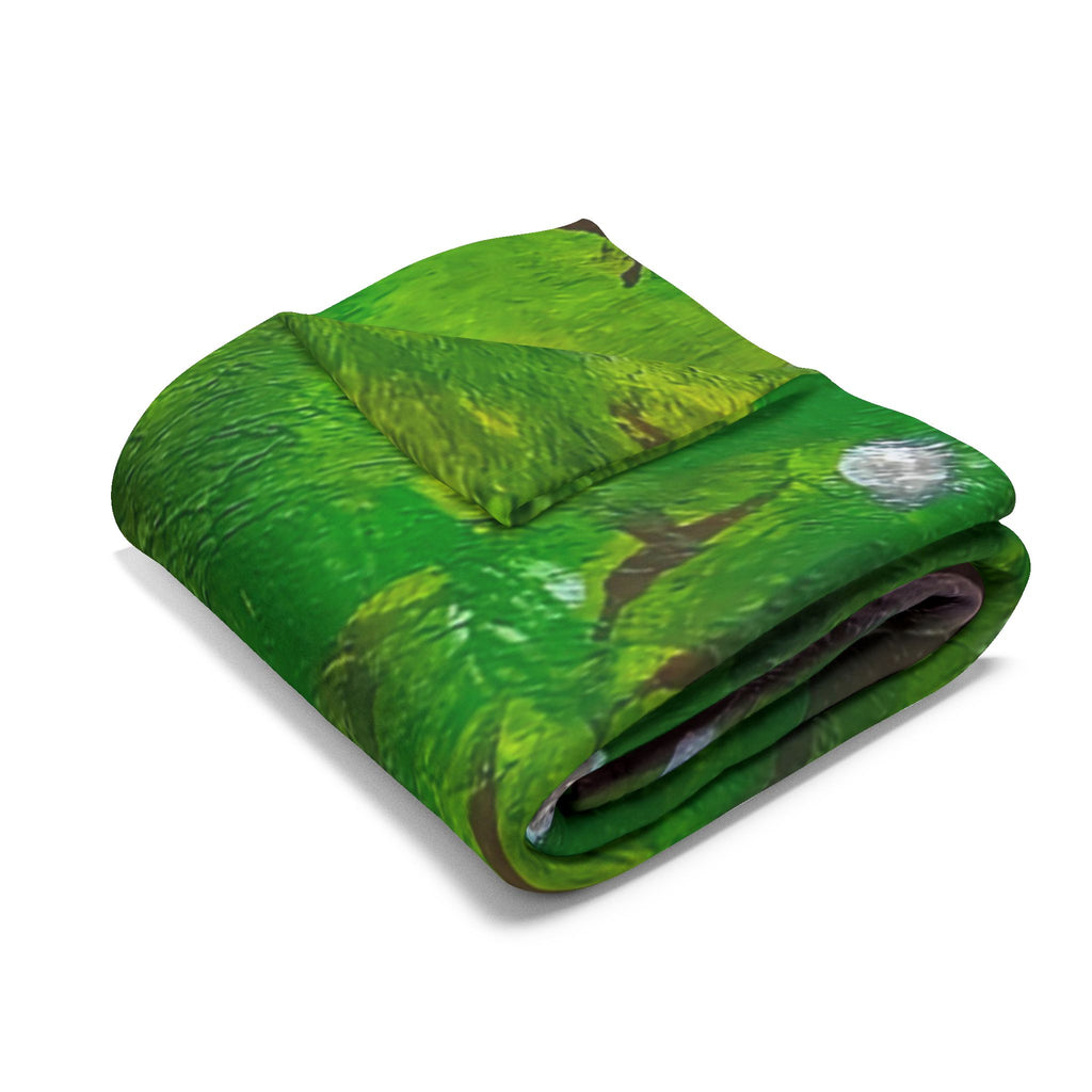 Folded green fleece blanket with gray moon and branch details in mushroom scene