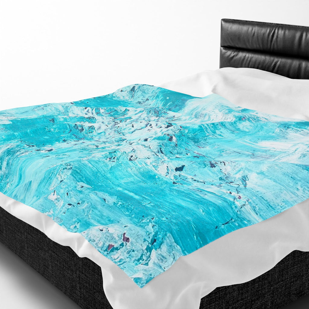 Close-up of turquoise abstract plush blanket with crumpled texture and white border