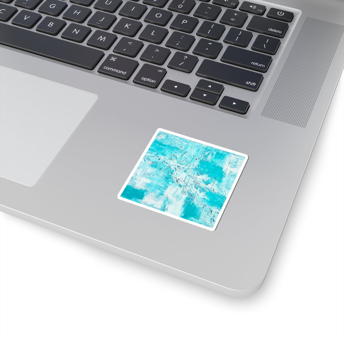 Teal abstract art sticker with white border on laptop