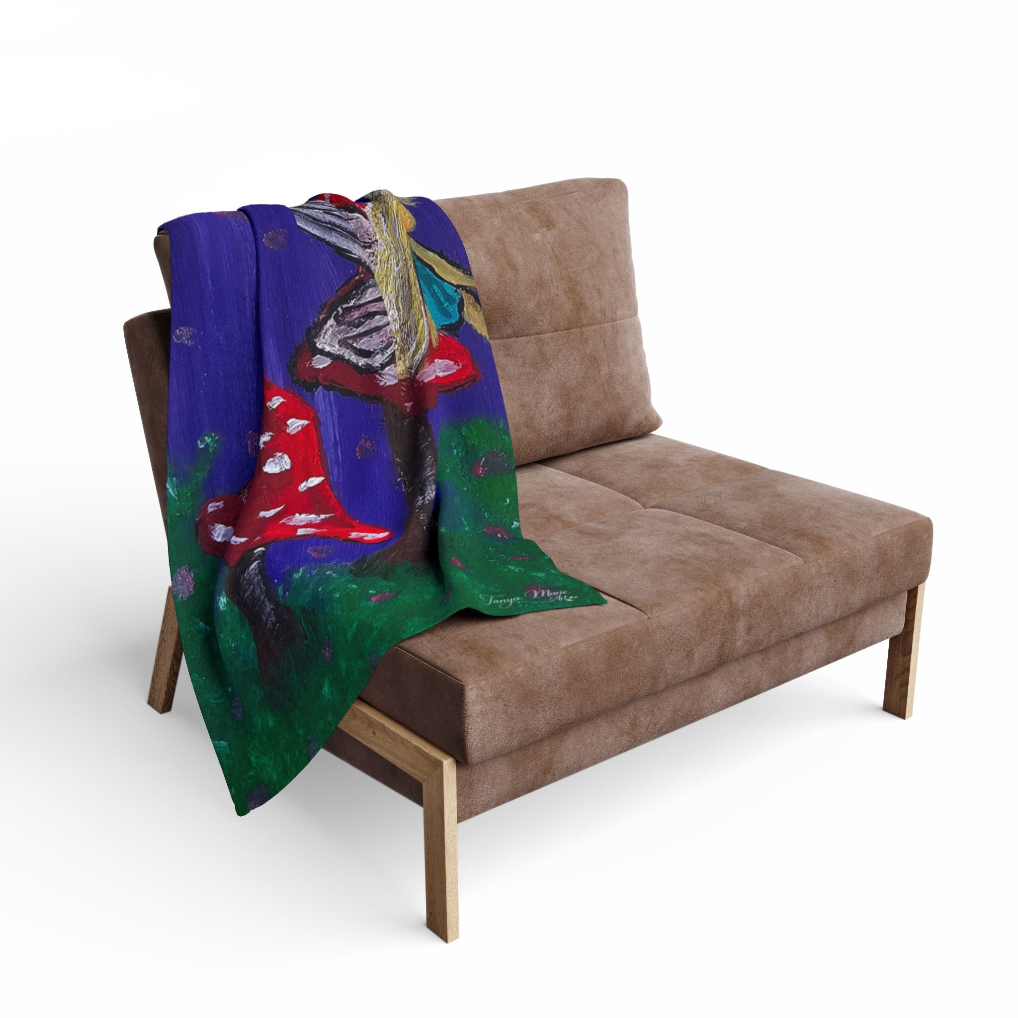 Fleece throw draped over couch with blue fairy-and-mushroom artwork in red and green