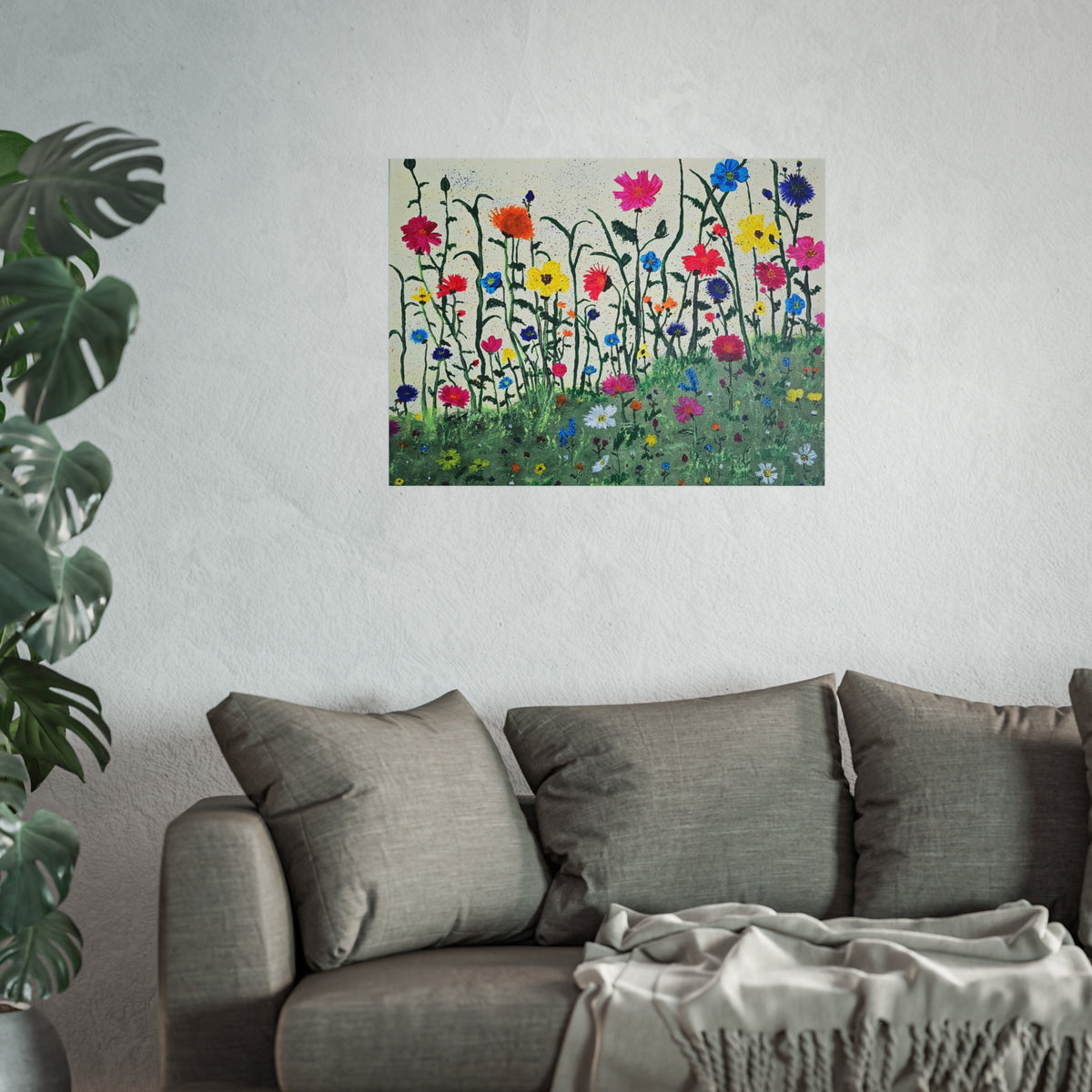 Matte wildflower art poster on wall above gray sofa with folded throw blanket