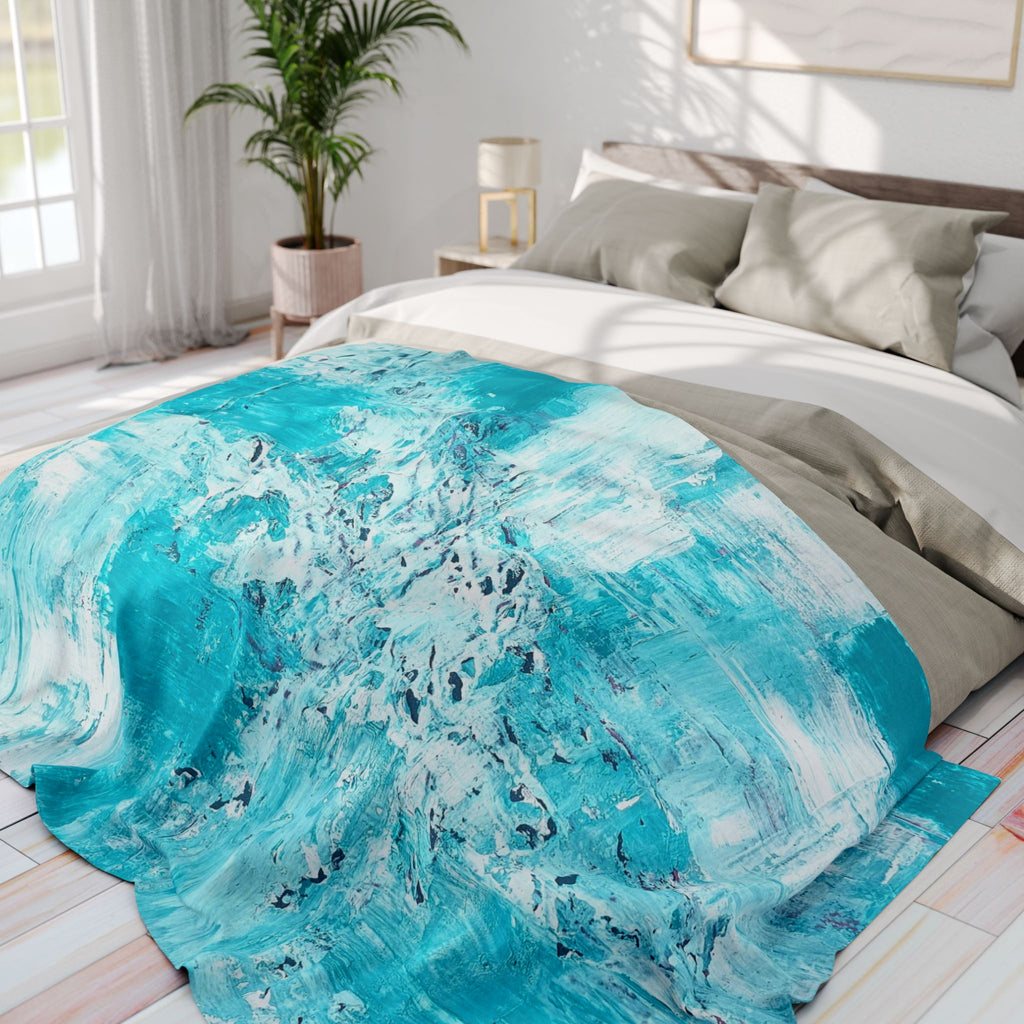 Turquoise abstract fleece blanket on bed, splash-streak pattern partially covering