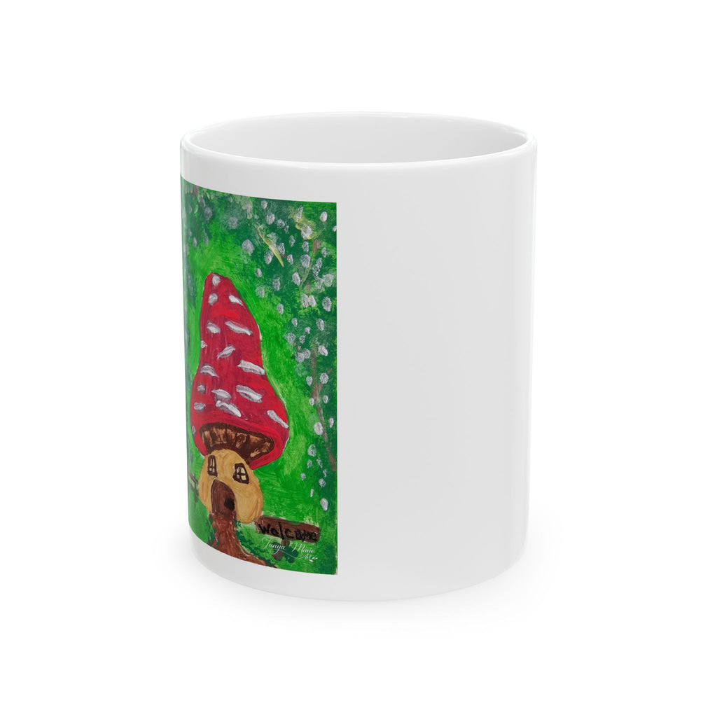 White ceramic coffee mug showing green background with red mushroom and small house